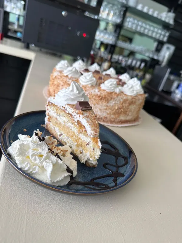 Stück Torte mit Sahne und Schokoladensauce
